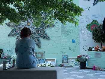 A woman reflecting at the Grenfell memorial wall