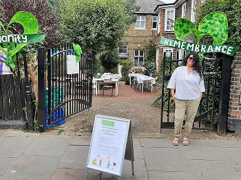 Remembrance drop in building entrance with a woman next to it