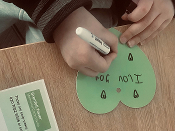 Person writing a message on a heart